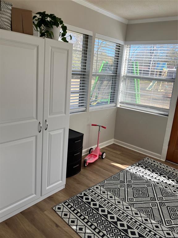233 Church Road Stonewall, LA 71078 - Photo 26 of 32 Bedroom featuring ornamental molding, multiple windows, dark wood finished floors, and a textured ceiling