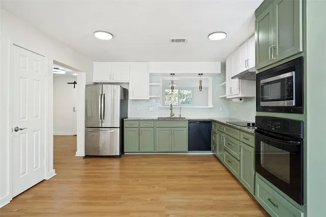 a kitchen with a refrigerator and a stove top oven