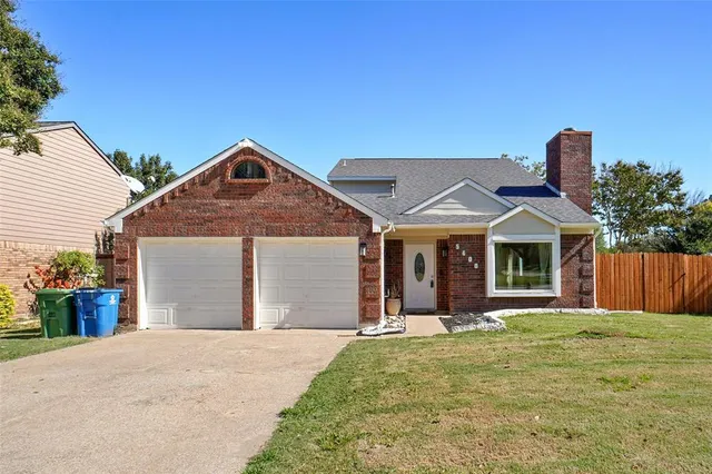 a front view of a house with a yard and potted plants