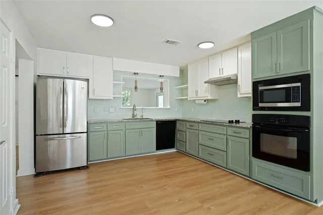 a kitchen with granite countertop stainless steel appliances and wooden cabinets