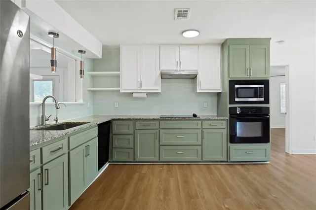 a kitchen with stainless steel appliances a sink cabinets and wooden floor