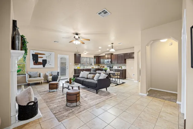 a living room with lots of furniture and view of kitchen