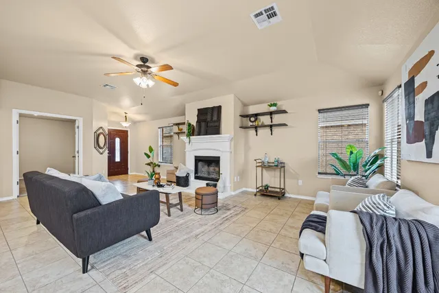 a living room with furniture a fireplace and a flat screen tv