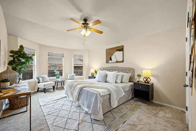 a bedroom with a bed a couch and a chandelier