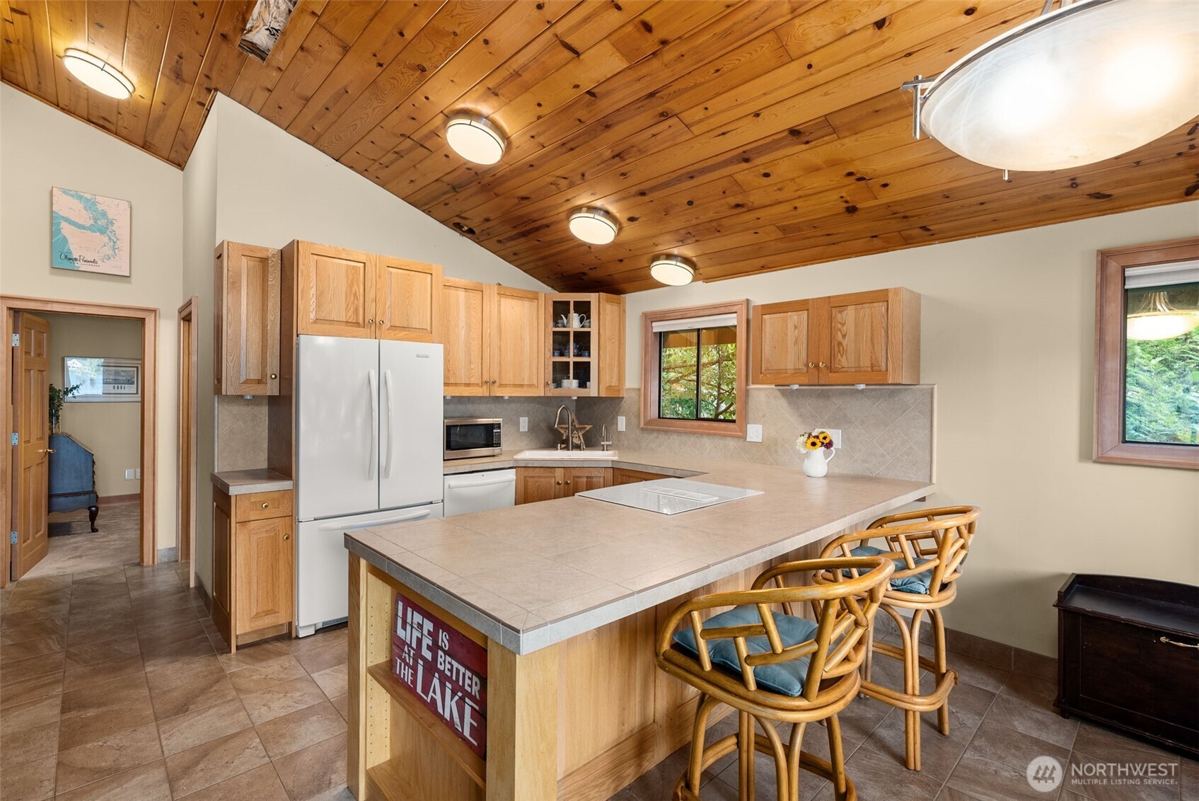 2147 Summit Lake Shore Road Northwest Olympia, WA 98502 - Photo 19 of 38 a kitchen with stainless steel appliances granite countertop a dining table chairs refrigerator and cabinets