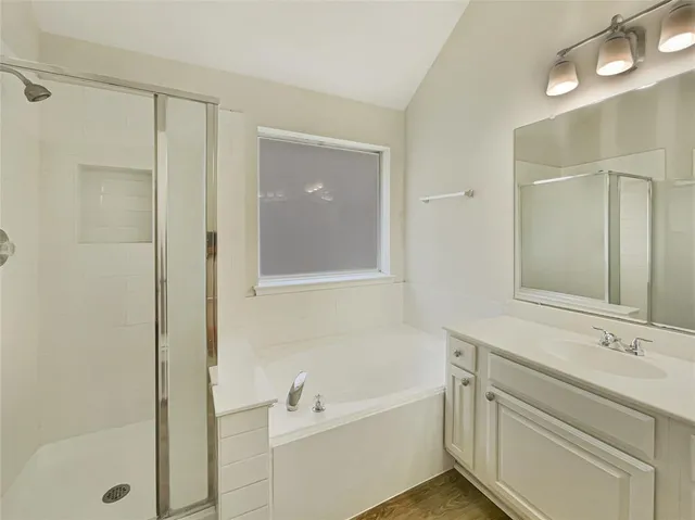 a bathroom with a tub sink and mirror