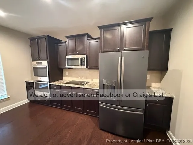 a kitchen with stainless steel appliances granite countertop a refrigerator and a stove