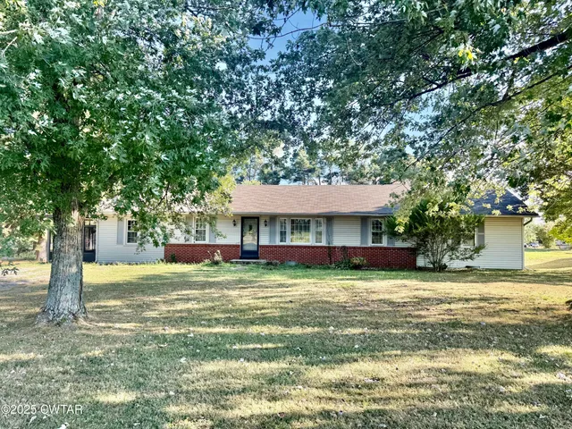 a view of a house with a yard and tree