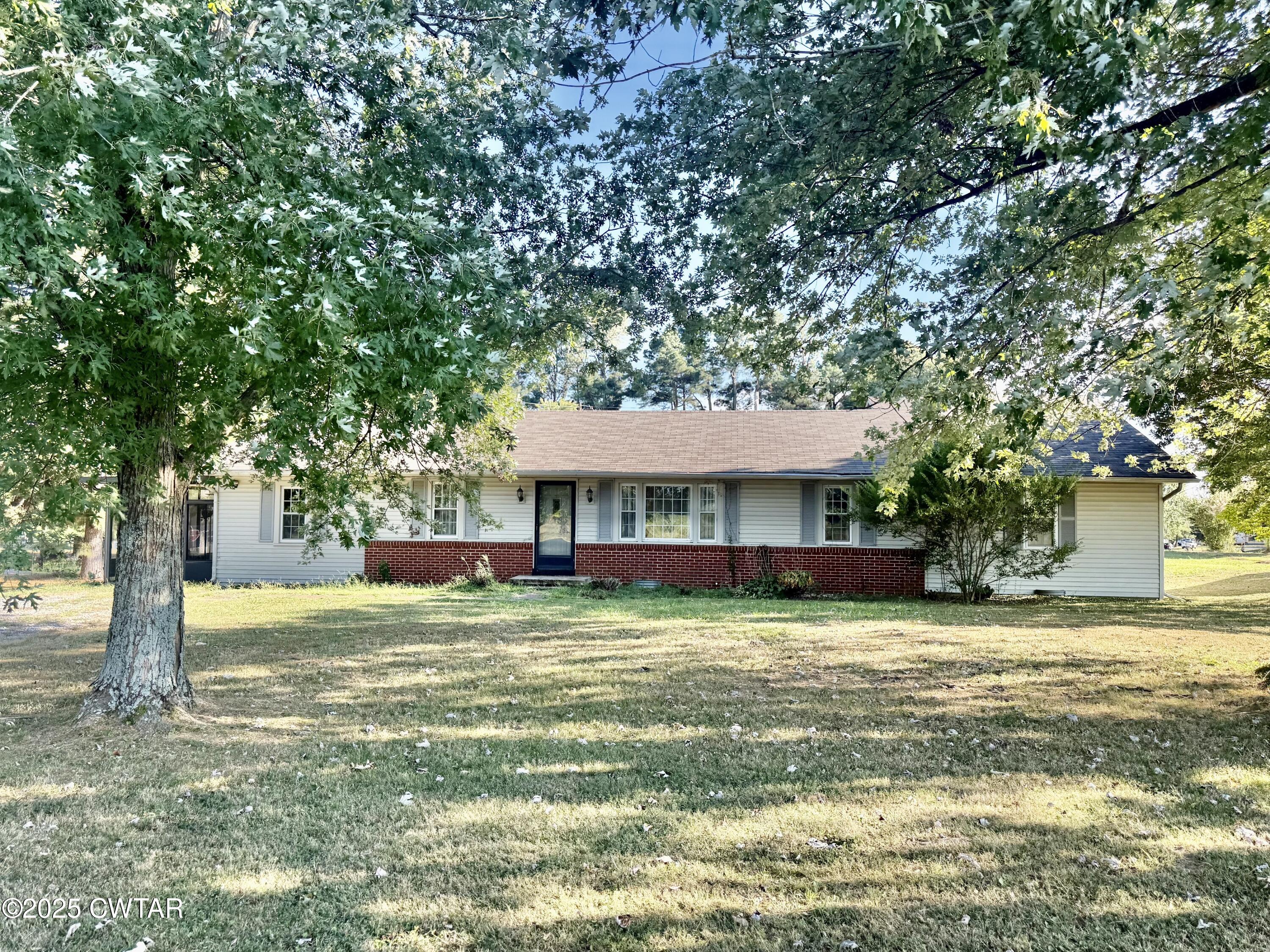 a view of a house with a yard and tree