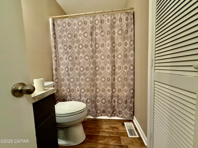 a bathroom with a toilet and a shower curtain