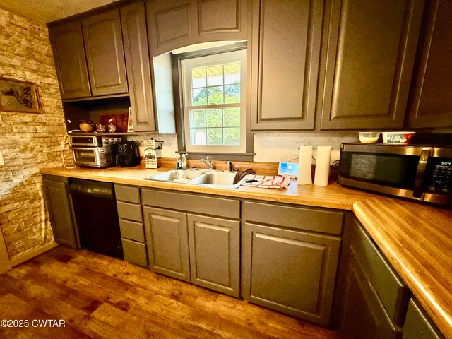 a kitchen with stainless steel appliances granite countertop a sink stove and cabinets