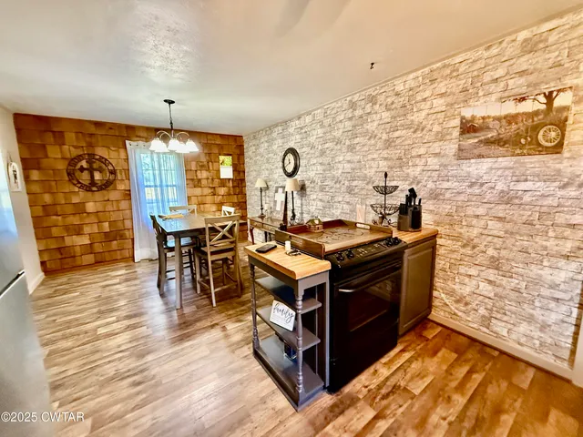a kitchen with stainless steel appliances granite countertop a stove and a wooden floors