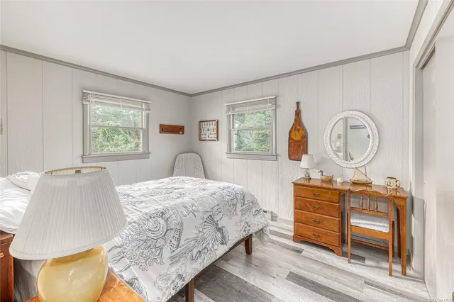 a bedroom with a bed a dresser and window