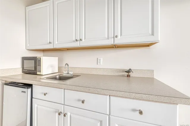 a kitchen with white cabinets and a sink