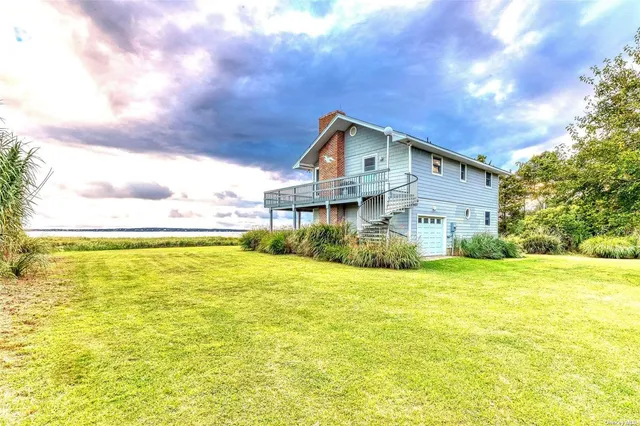 a view of a house next to a big yard with large trees