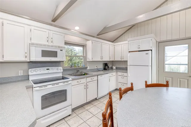 a kitchen with white cabinets and white appliances