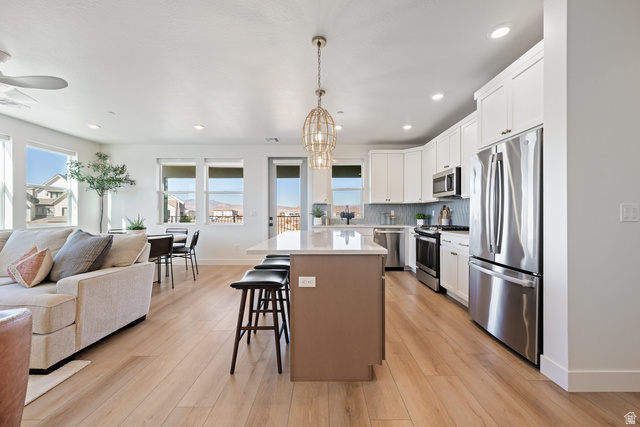 762 West Periwinkle Lane, Unit 102 St. George, UT 84790 - Photo 39 of 40 Kitchen featuring open floor plan, stainless steel appliances, a kitchen island, light wood finished floors, and two tone color scheme