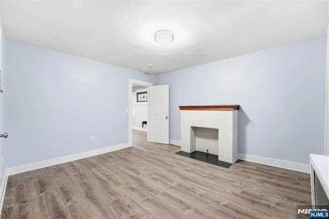 a view of an empty room with a fireplace and a window