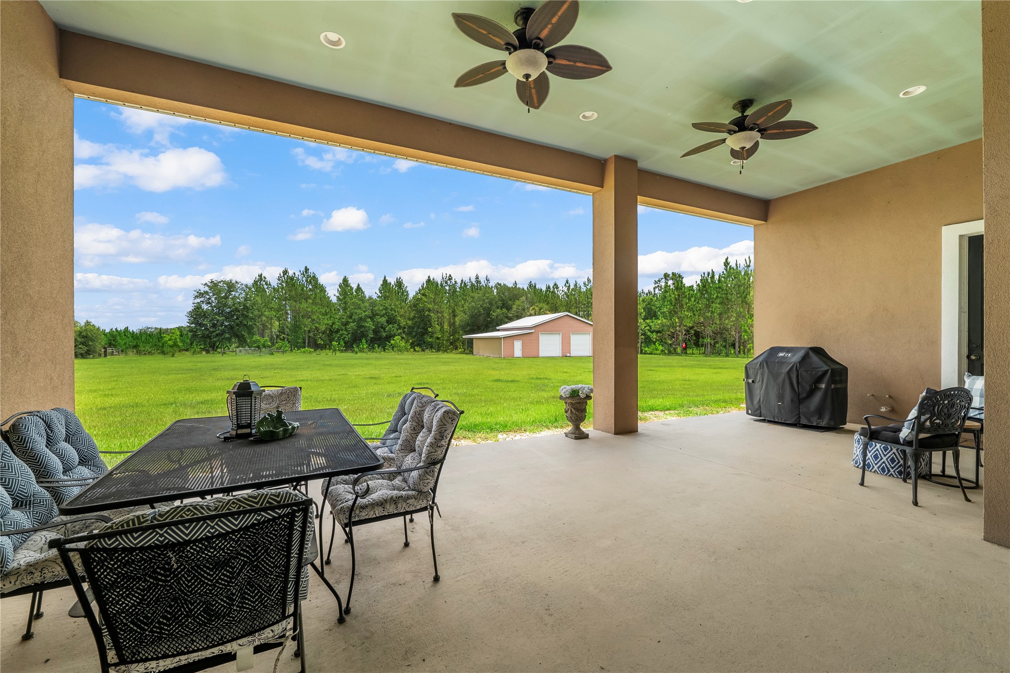 27247 Hallman Road Hilliard, FL 32046 - Photo 29 of 59 a view of a patio with a table chairs and a floor to ceiling window