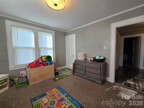a view of a hallway with wooden floor and a bathroom