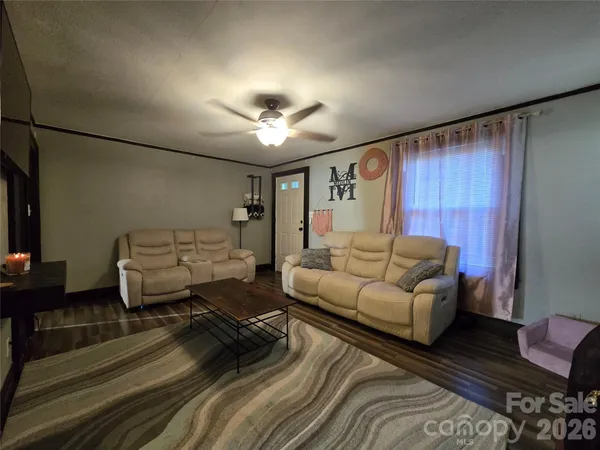 a living room with furniture and a ceiling fan