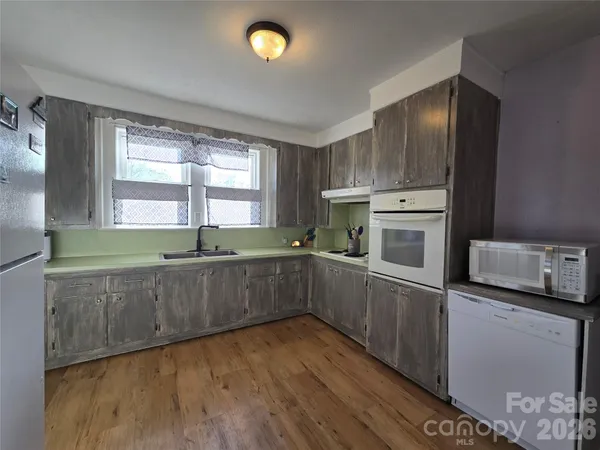 a kitchen with stainless steel appliances granite countertop a sink and wooden cabinets