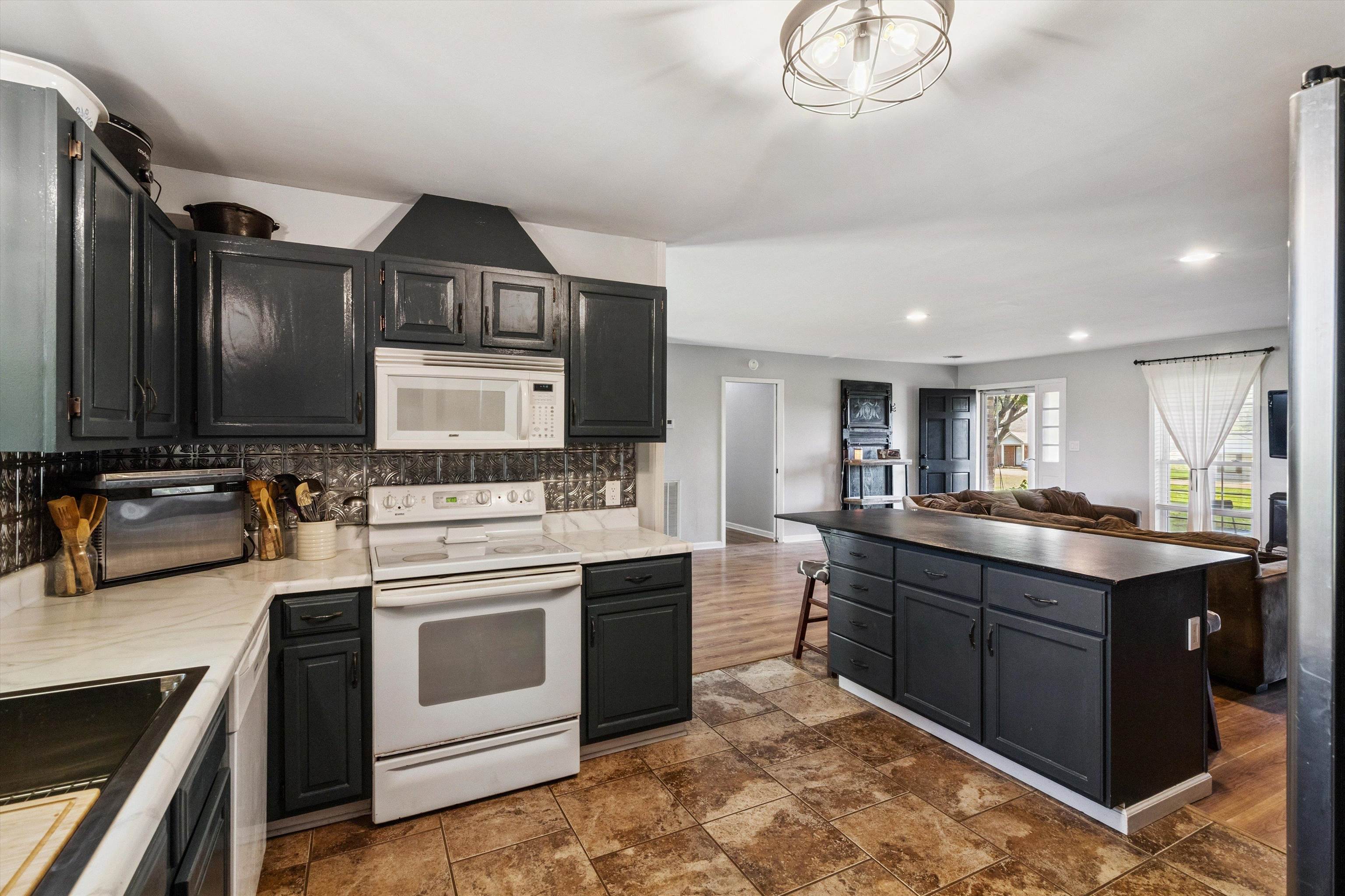 202 Holly Grove Road Covington, TN 38019 - Photo 32 of 32 Kitchen with appliances with stainless steel finishes, backsplash, open floor plan, dark cabinetry, and recessed lighting