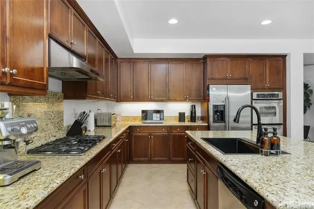 a kitchen with granite countertop a sink a stove and cabinets