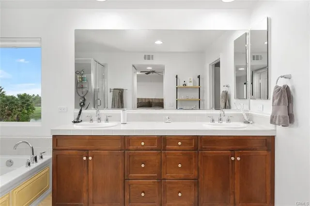 a bathroom with a granite countertop sink double vanity and a mirror