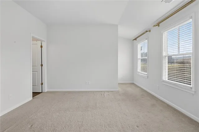 an empty room with wooden floor and cabinet space