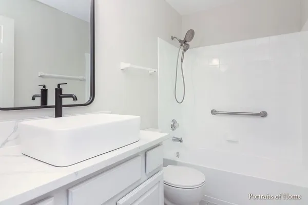 a bathroom with a granite countertop sink a toilet and a shower