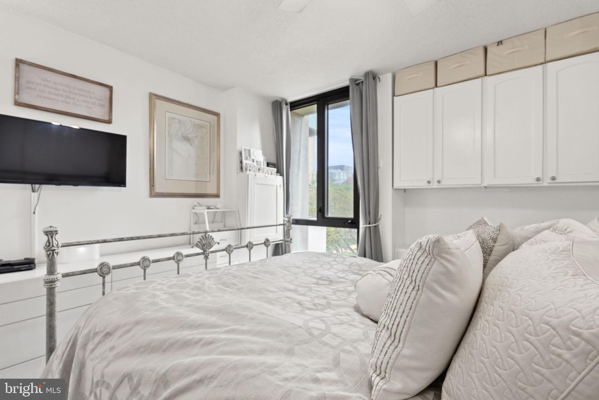 1250 4th Street Southwest, Unit W107 Washington, DC 20024 - Photo 21 of 30 a large bedroom with a bed and a flat screen tv