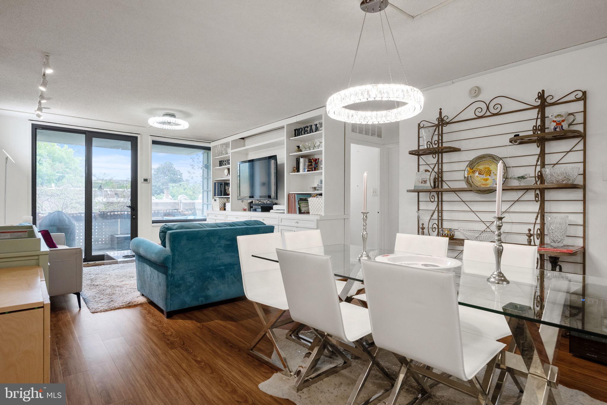 1250 4th Street Southwest, Unit W107 Washington, DC 20024 - Photo 5 of 30 a living room with furniture a dining table and a chandelier