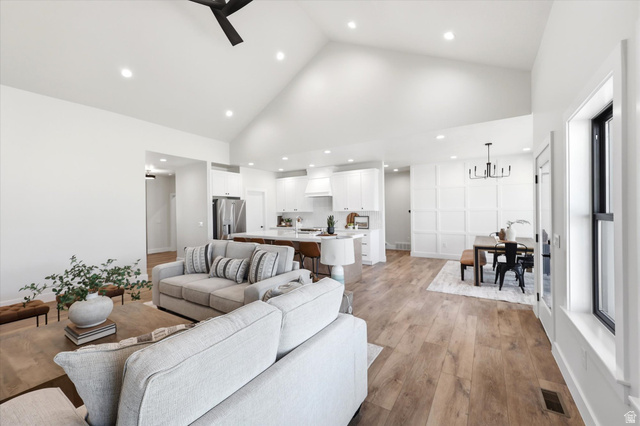 134 South Chamberlain Street Mapleton, UT 84664 - Photo 12 of 40 Vaulted ceilings, wood-finish flooring, recessed lighting, white shaker cabinetry, and a kitchen island with seating