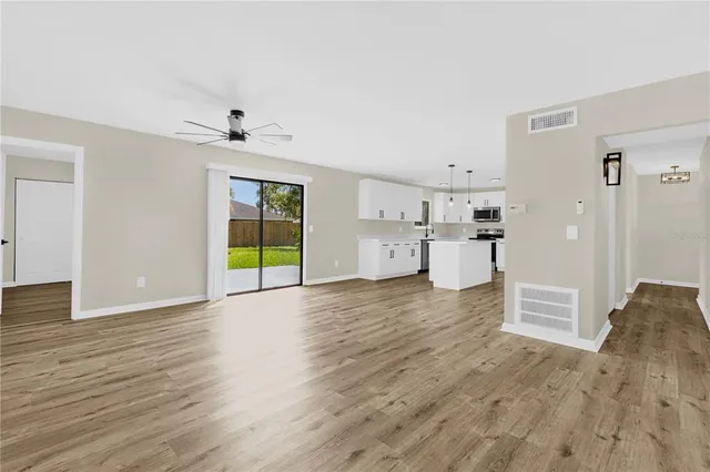 a view of empty room with wooden floor