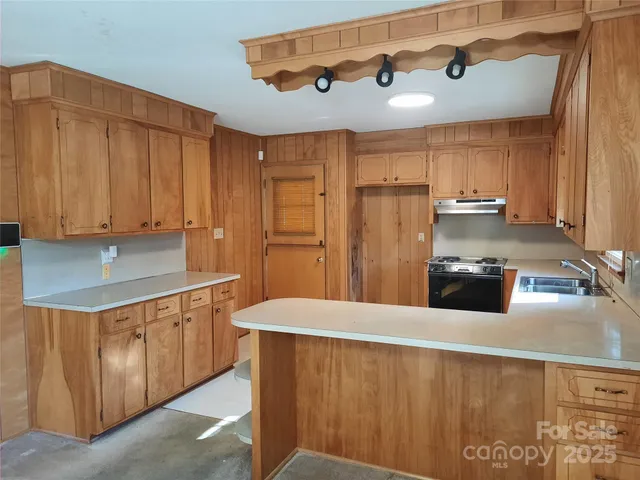 a kitchen with stainless steel appliances granite countertop a sink a refrigerator and a stove