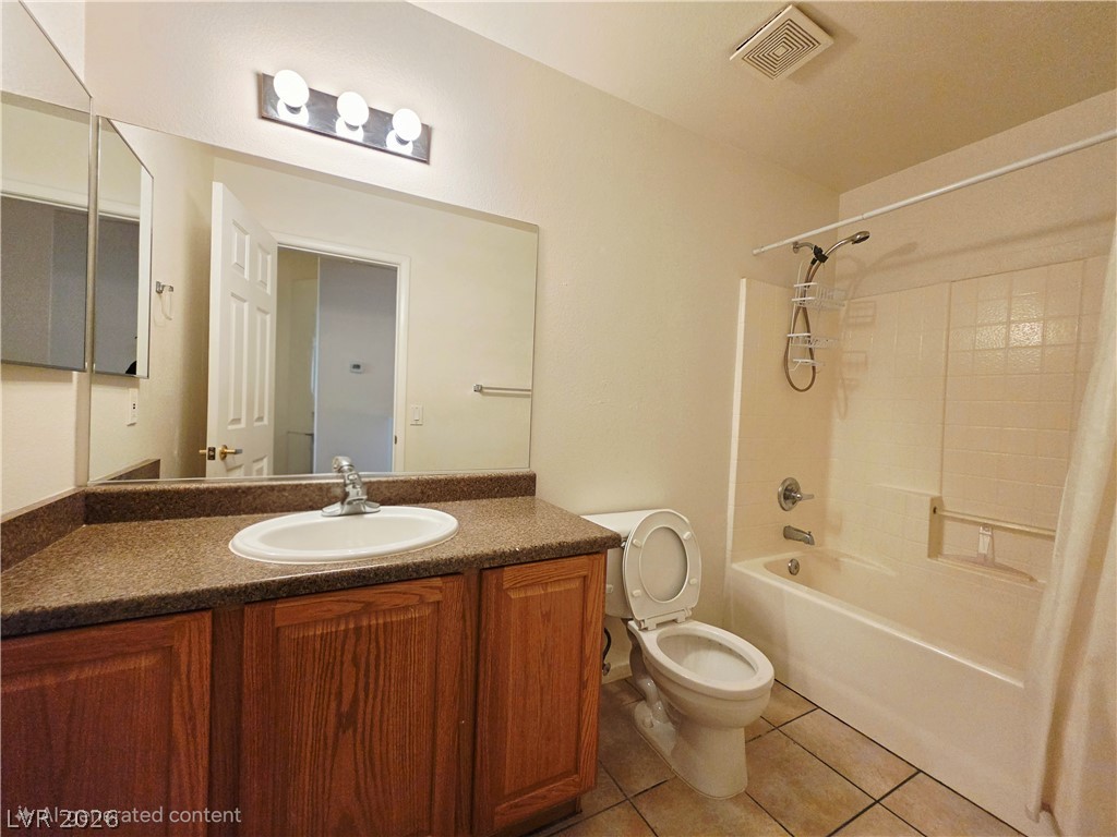 1571 Rusty Ridge Lane Henderson, NV 89002 - Photo 23 of 26 Well-lit bathroom features a spacious vanity and a convenient shower-tub combination.