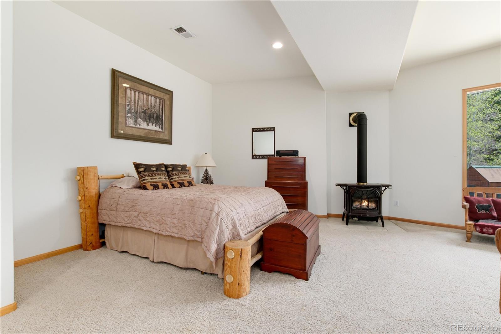 1211 Hughesville Road Black Hawk, CO 80422 - Photo 27 of 39 a spacious bedroom with a bed and a chair