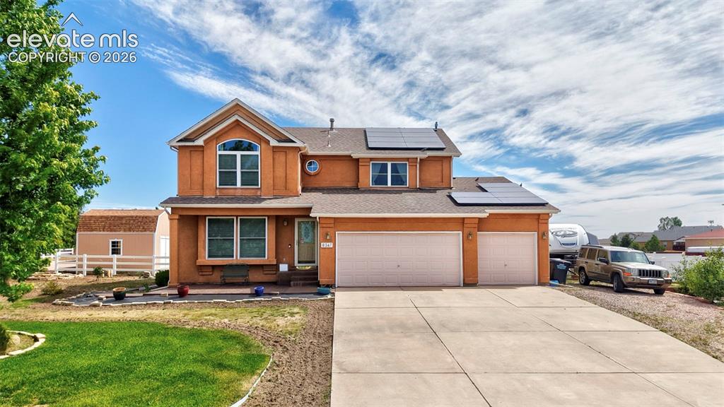 8347 Tibbs Road Peyton, CO 80831 - Photo 34 of 39 Two-story stucco residence with a concrete driveway, attached two-car garage, and solar panels
