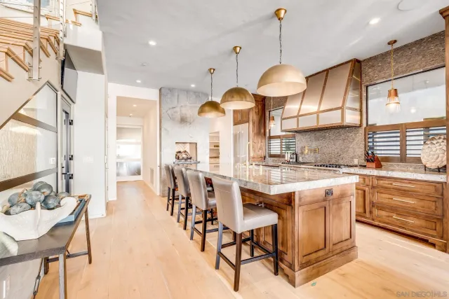 a kitchen with stainless steel appliances granite countertop a stove a sink a oven with a dining table and chairs