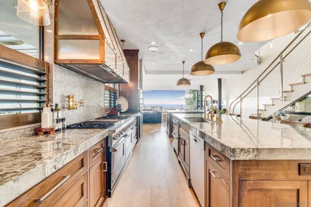 a kitchen with stainless steel appliances granite countertop a sink a stove and a wooden floors