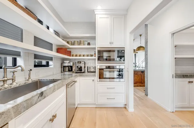 a kitchen with stainless steel appliances kitchen island granite countertop a refrigerator and a sink