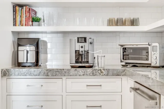 a kitchen with granite countertop stainless steel appliances counter space cabinets and wooden floor