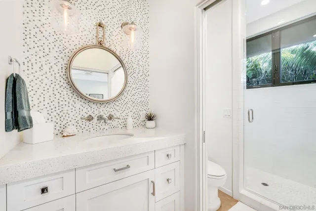 a bathroom with a sink a toilet and shower