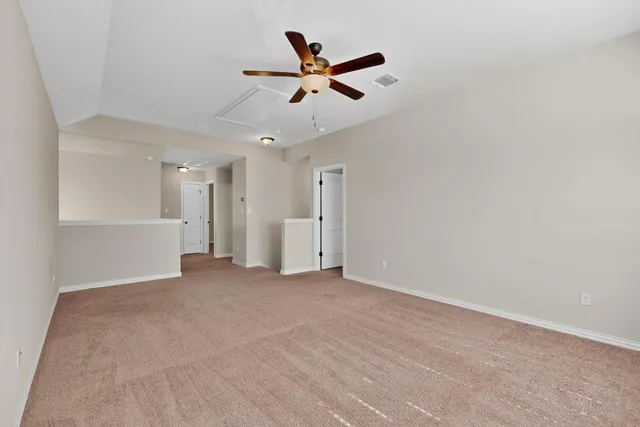 a view of a livingroom with a ceiling fan and window