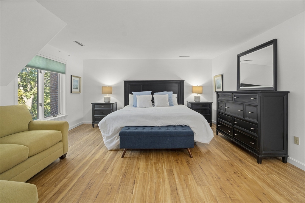 26 Quarry Ridge Lane, Unit 26 Rockport, MA 01966 - Photo 18 of 37 a spacious bedroom with a bed and wooden floor