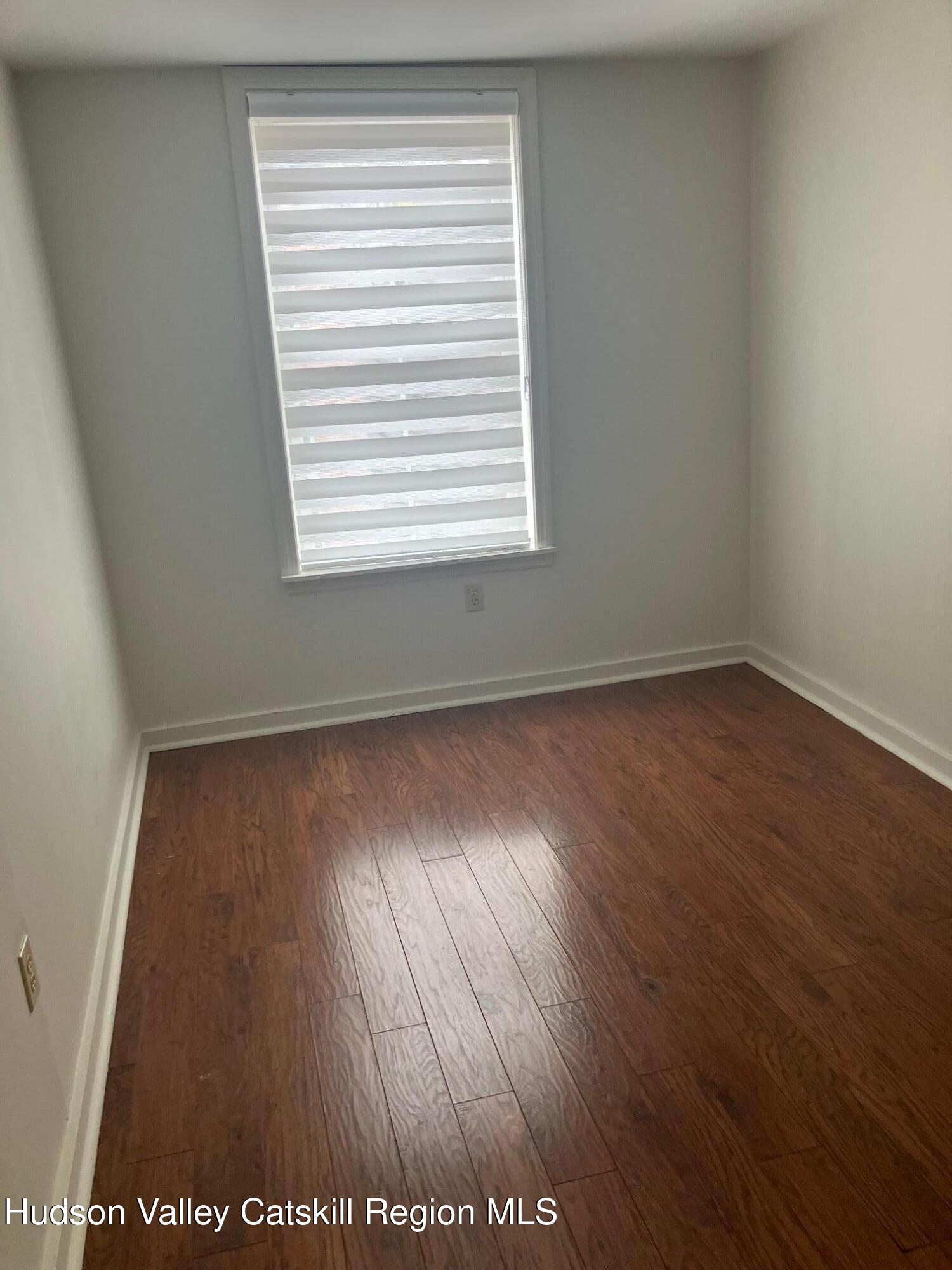 434 Warren Street Hudson, NY 12534 - Photo 6 of 10 an empty room with wooden floor and windows