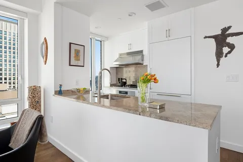 a kitchen with kitchen island a sink appliances and a counter top space