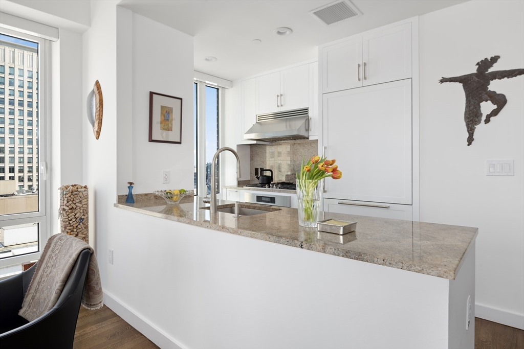 400 Stuart Street, Unit 17B Boston, MA 02116 - Photo 4 of 12 a kitchen with kitchen island a sink appliances and a counter top space