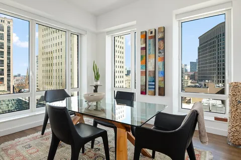 a dining room with furniture and large windows